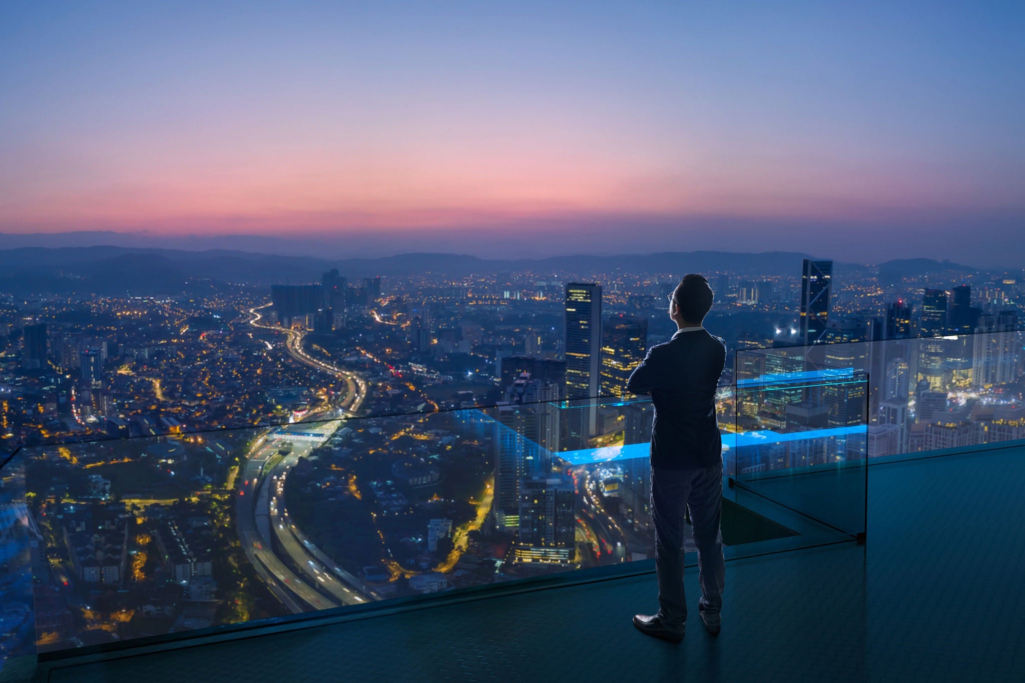 Personne sur un toit observant la vue de la ville au coucher du soleil