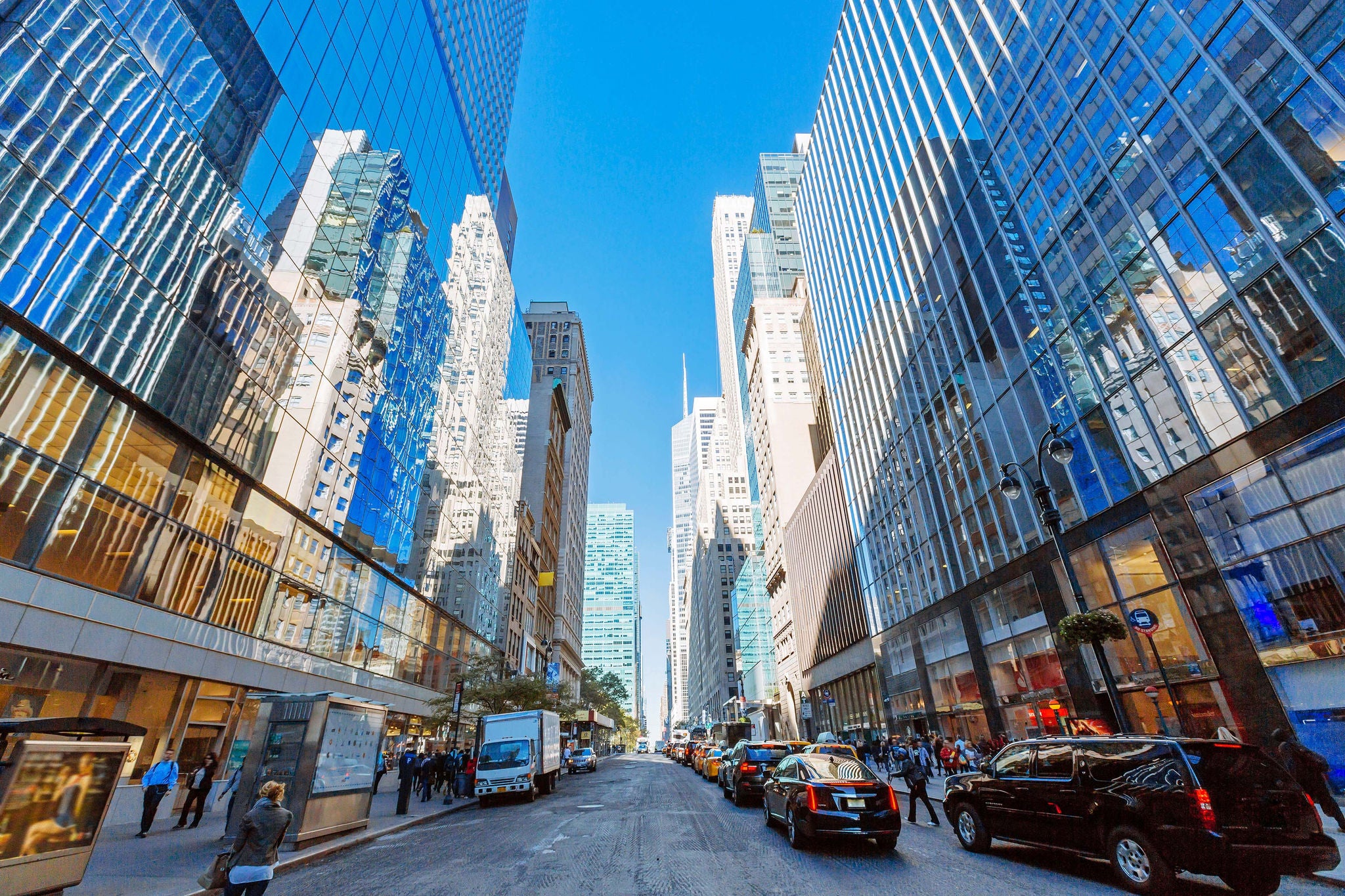 Rue animée bordée de gratte-ciel en verre par temps clair