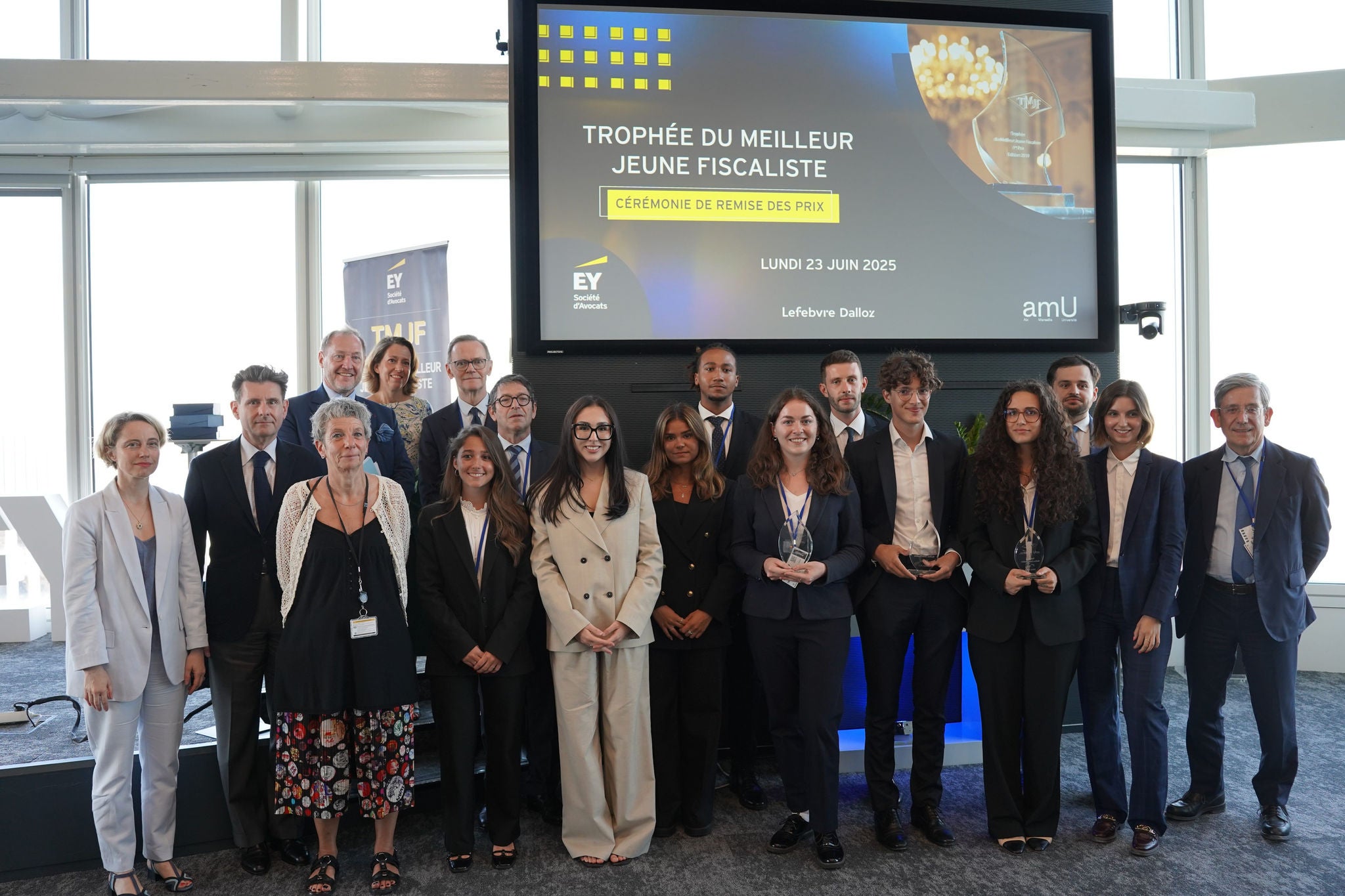 Photo de groupe lors dune cérémonie de remise de prix devant un écran