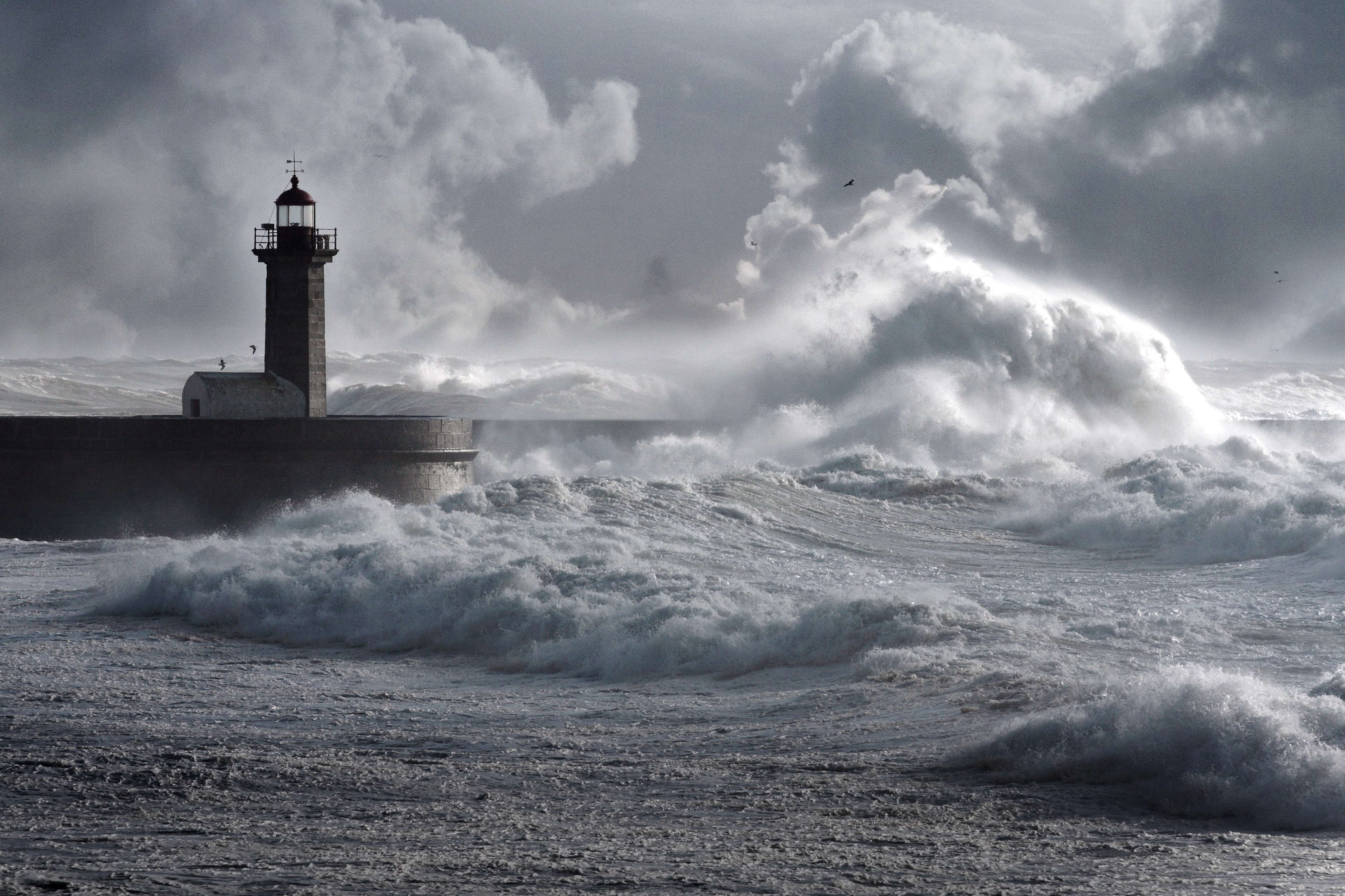 Vagues de tempete s ecrasant contre un phare pendant une forte maree